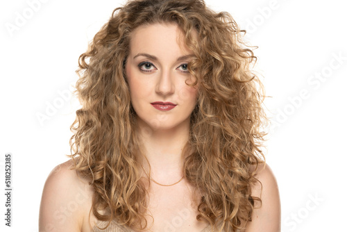 Attractive blonde woman with curly beautiful hair posing on white background