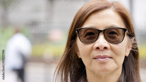 Portrait of senior Asian female looking to camera with space for text