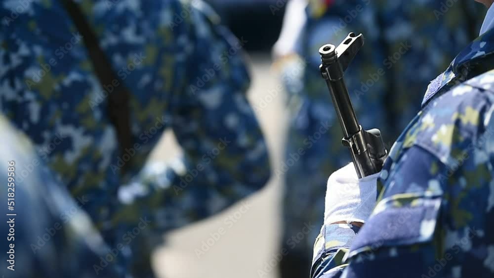Soldiers in blue camouflage uniforms are seen in formation during military ceremony	