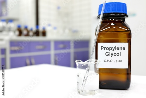 Selective focus of propylene glycol liquid chemical compound in dark glass bottle inside a chemistry laboratory with copy space. photo