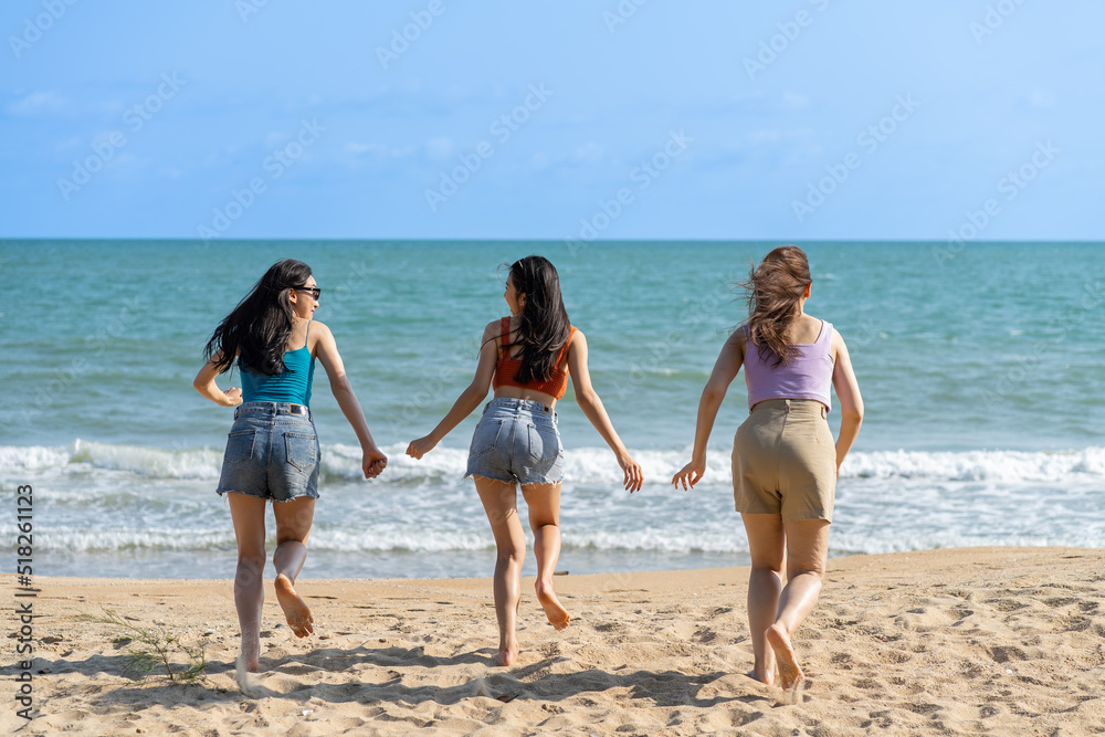 Group of Asian beautiful young women having fun, playing on the beach. Attractive friends feel happiness and fun while walking or running at seaside enjoy vacation holiday trip in tropical sea island.