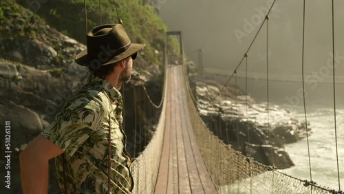 Happy travel man on vacation concept. Funny traveler enjoy her trip and ready to adventure. man tourist hiker on rocky trail crossing a wooden bridge over Norway scandinavian landscape background. photo