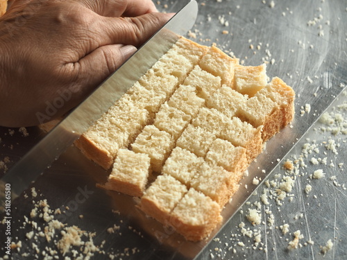 slicing white bread into cubes for making croutons photo