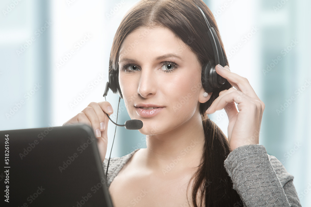 young friendly looking female call center agent with headset and monitor young friendly looking female call center agent with headset and monitor