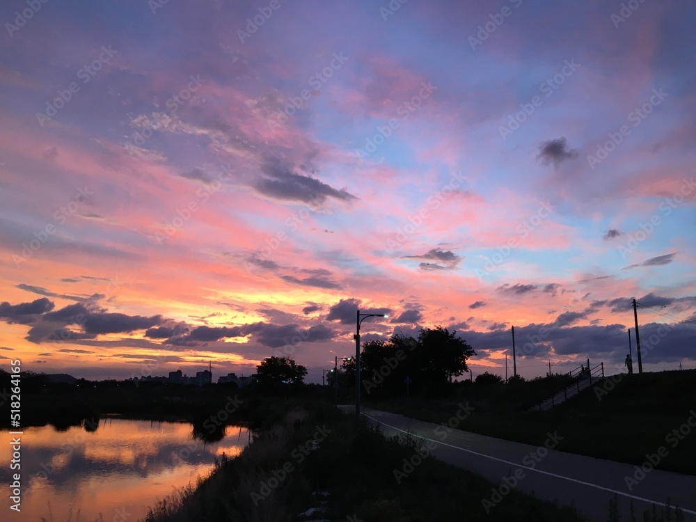 Beautiful sky with clouds and river at sunset.