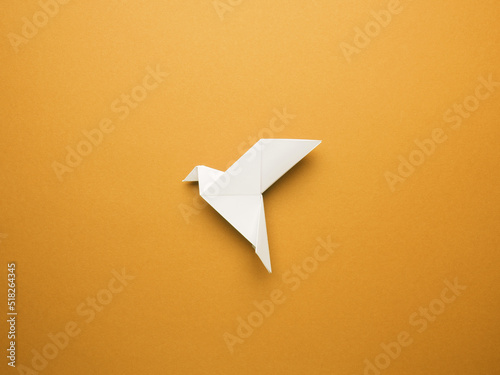 Billede på lærred Origami peace dove on an orange paper background, freedom or peace concept