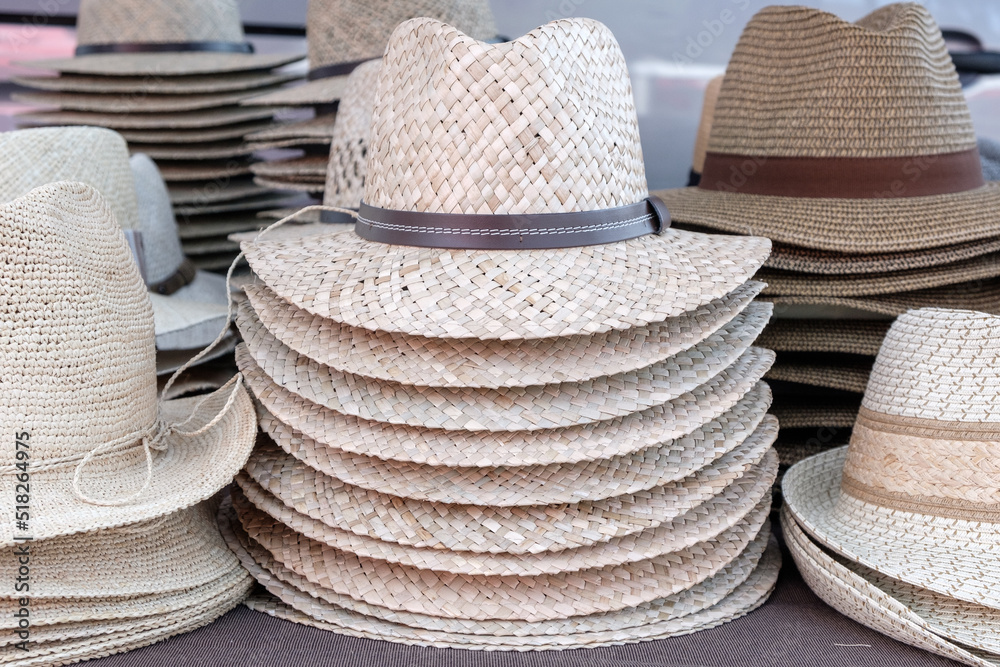 Pile of mediterranean straw summer hats on a market.