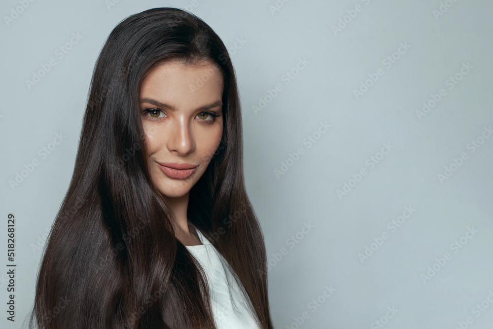 Fashion beauty portrait of stylish brunette model woman with long dark hairstyle and makeup smiling on gray background Fashion beauty portrait of stylish brunette model woman with long dark hairstyle and makeup smiling on gray background