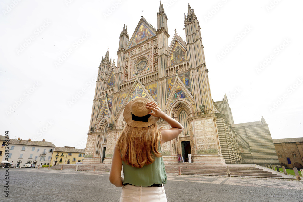 Fototapeta premium Holidays in Italy. Tourist woman enjoying view the well reserved Cathedral of Orvieto, Umbria, Italy.
