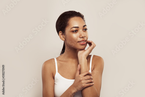 Attractive woman with clean skin looking aside, smiling and thinking on white. Skincare and facial treatment concept