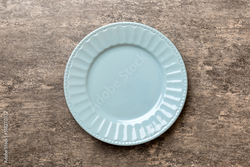 Top view of empty grey plate on cement background. Empty space for your design