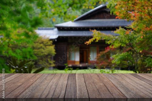 Wooden table top with blurred garden and japan house.   