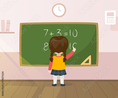 Kid writing equation on the chalkboard. Schoolgirl learning math in the classroom. Girl in front of the school blackboard.