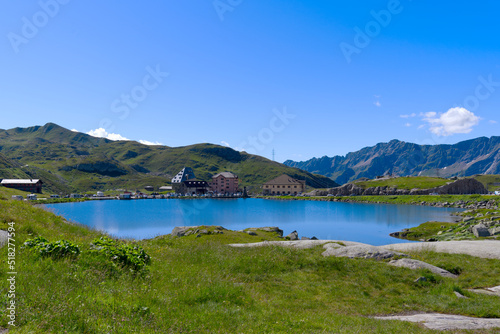 Scenic landscape at hiking trail at Swiss mountain pass St. Gotthard with mountain lake and historic Tremola road on a sunny summer day. Photo taken June 25th, 2022, Gotthard Pass, Switzerland.