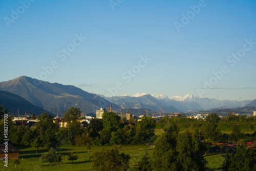 Skyline of City of Baar and Zug with Swiss Alps in the background on a sunny summer day. Photo taken June 25th, 2022, Zug, Switzerland.