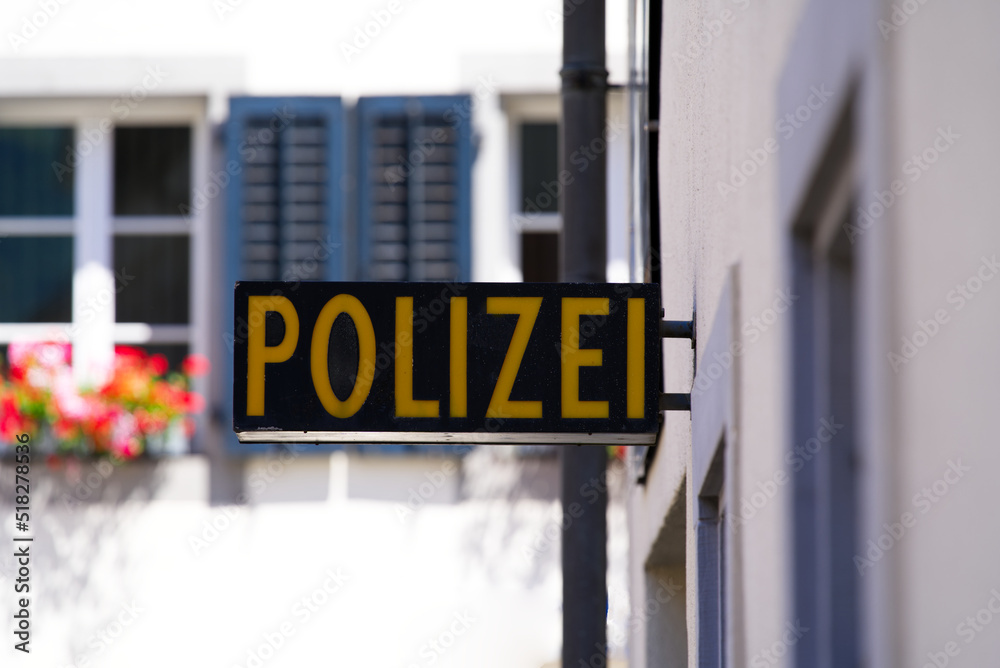 Obraz premium Close-up of black and yellow police (German Polizei) sign at police station at City of Altdorf, Canton Uri, on a sunny summer day. Photo taken June 25th, 2022, Altdorf, Switzerland.