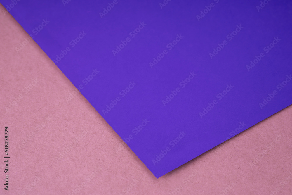 Plain purple paper sheet lying on pink peach textured Background like an open book from top angle Plain purple paper sheet lying on pink peach textured Background like an open book from top angle