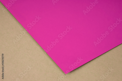 Plain pink paper sheet lying on brown textured Background like an open book from top angle 