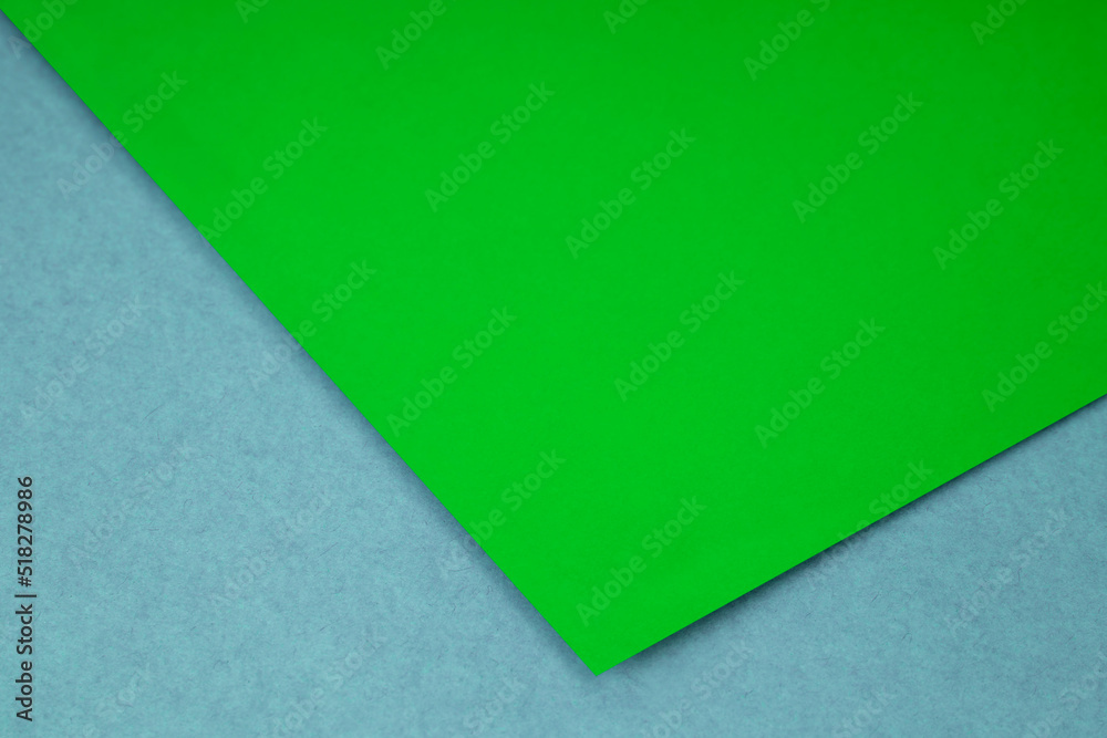 Plain lime green paper sheet lying on blue grey textured Background like an open book from top angle Plain lime green paper sheet lying on blue grey textured Background like an open book from top angle