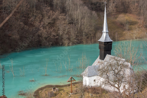 Toxic waste waters from a copper and gold mine submerge village. Abandoned orthodox church on lakeside photo