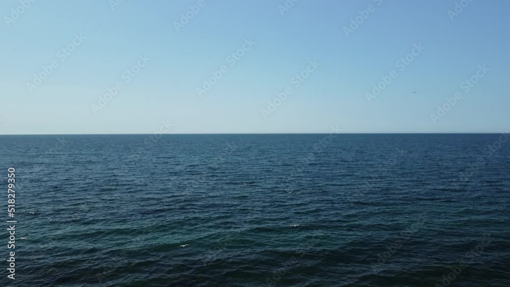 Aerial view from above on calm azure sea and volcanic rocky shores. Small waves on water surface in motion blur. Nature summer ocean sea beach background. Nobody. Holiday, vacation and travel concept Aerial view from above on calm azure sea and volcanic rocky shores. Small waves on water surface in motion blur. Nature summer ocean sea beach background. Nobody. Holiday, vacation and travel concept