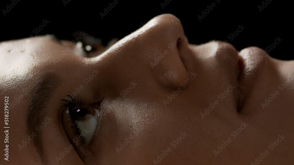 Naklejka premium Big close-up shot of young good-looking African American female model's face on black background | Eyes care concept