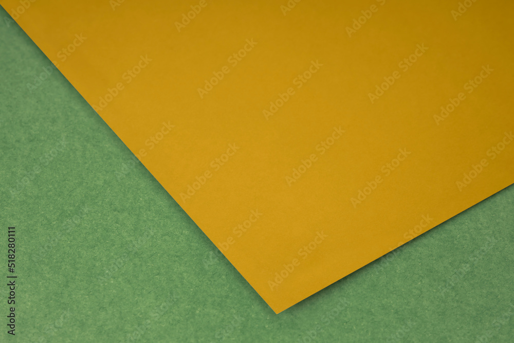Plain Yellow paper sheet lying on yellow green textured Background like an open book from top angle Plain Yellow paper sheet lying on yellow green textured Background like an open book from top angle