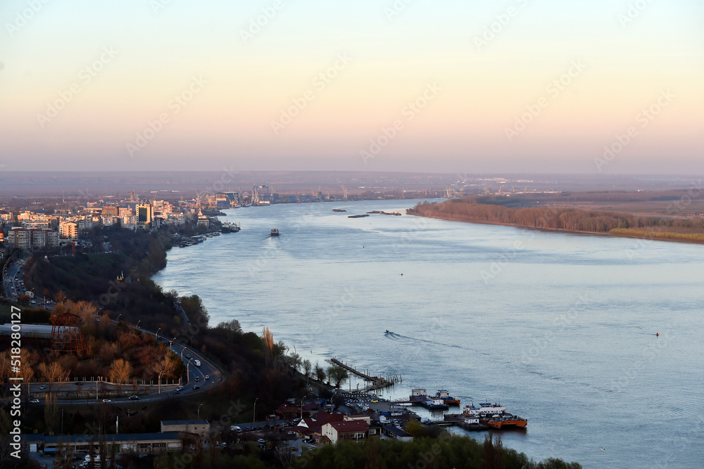 Aerial photography of cargo ships sail on the Danube river at sunset near Galati city, Romania.