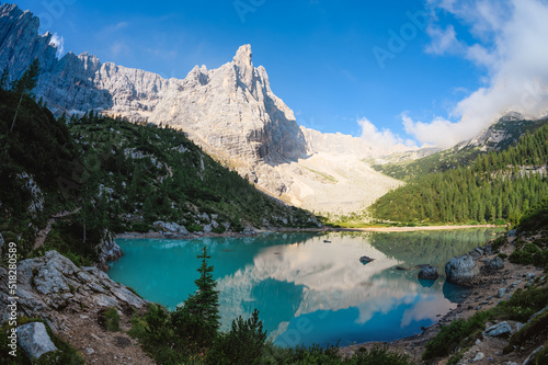 Fototapeta Naklejka Na Ścianę i Meble -  Stunning view of Lake Sorapis with its turquoise waters and surrounded by beautiful rocky mountains.  Lake Sorapis is one of the most beautiful excursions in the Dolomites, Italy.