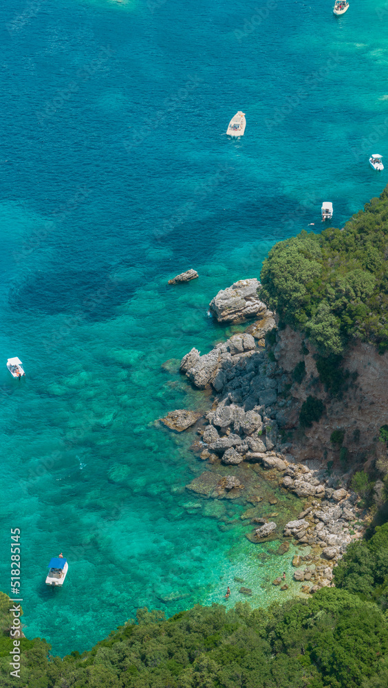 Aerial view of Klimatia Beach, close to Limni beach on the island of Corfu. Coastline. Transparent and crystalline water, moored boats and bathers. Vacation. Greece