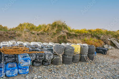 old fishermans lobster pots crab boxes barrels and deflated dingies in cardigan west wales UK