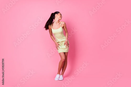 Full length photo of funny charming girl dressed yellow sarafan dancing empty space isolated pink color background