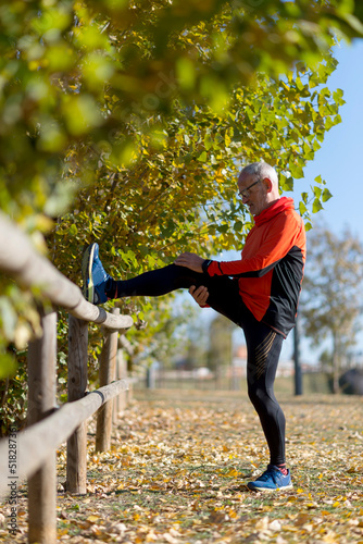 One senior man stretching his leg. Doing workout in nature. Healthy living.