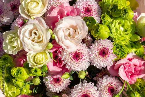 Bouquet of flowers consisting of eustoma, chrysanthemum, green rose. Floral background.