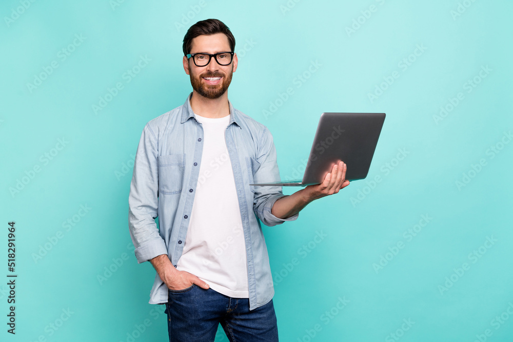 Portrait of confident satisfied person hold wireless netbook isolated on teal color background Portrait of confident satisfied person hold wireless netbook isolated on teal color background