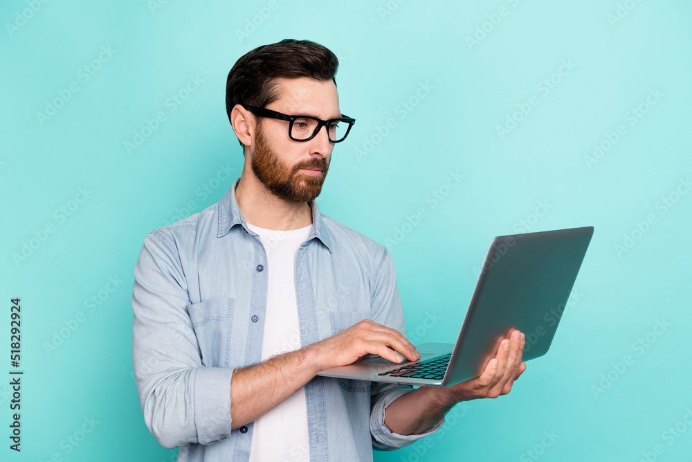 Photo of smart guy marketer use netbook chatting writing letters apps isolated on cyan color background Photo of smart guy marketer use netbook chatting writing letters apps isolated on cyan color background