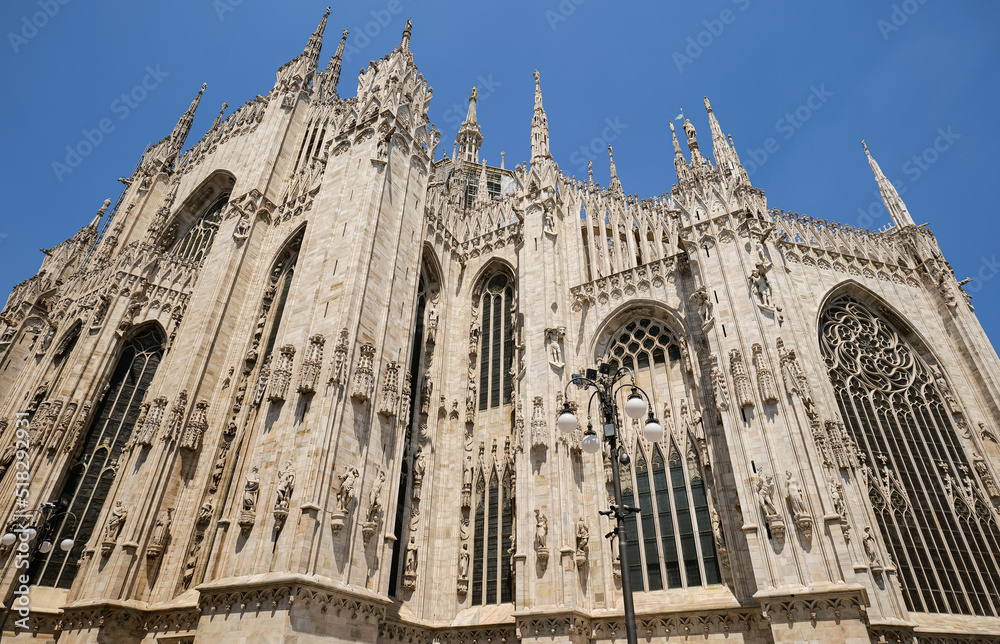 Wide angle view of the amazing architecture landmark Milan Cathedral (Italian Duomo di Milano) in a beautiful sunny day with blue sky. Travel to Italy.