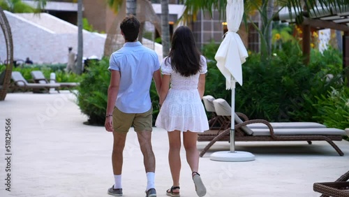 Young couple enjoys tropical resort. Hotel setting at all-inclusive travel destination. photo