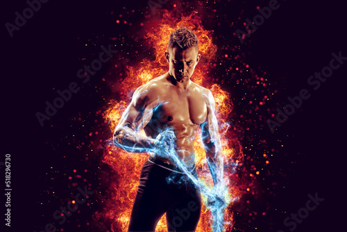 Muscular man with naked torso holding electric energy chain. Isolated on dark background with fire