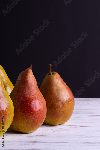 Ripe and juicy pears on a light wooden background