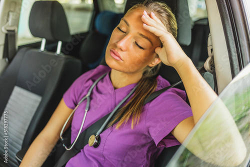 Принти на полотні Shot of a young female doctor looking sad and tired, sitting in her car dusing the day