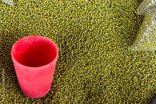 Mung beans, known locally as monggo, for sale at a stall in a public market. Measured with a cup. photo