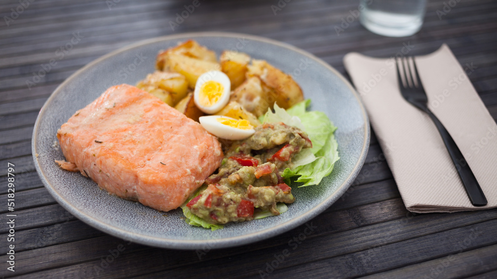 steamed salmon fillet with potato wedges, guacamole homemade and quail egg