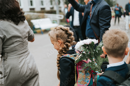back to school. little happy kid pupil schoolgirl eight years old in fashion uniform with backpack and hairstyle voluminous long braid ready going to second grade first day at primary school photo