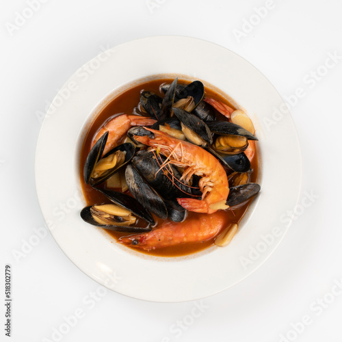 Schezwan Prawns in black bowl at dark slate background. Schezwan Prawns is indo-chinese cuisine curry dish with prawns or shrimps roasted in Schezwan Sauce.