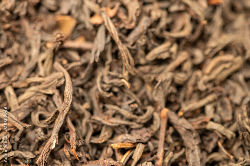 Large-leaved black tea in bulk on the table. Close-up of the surface texture Large-leaved black tea in bulk on the table. Close-up of the surface texture