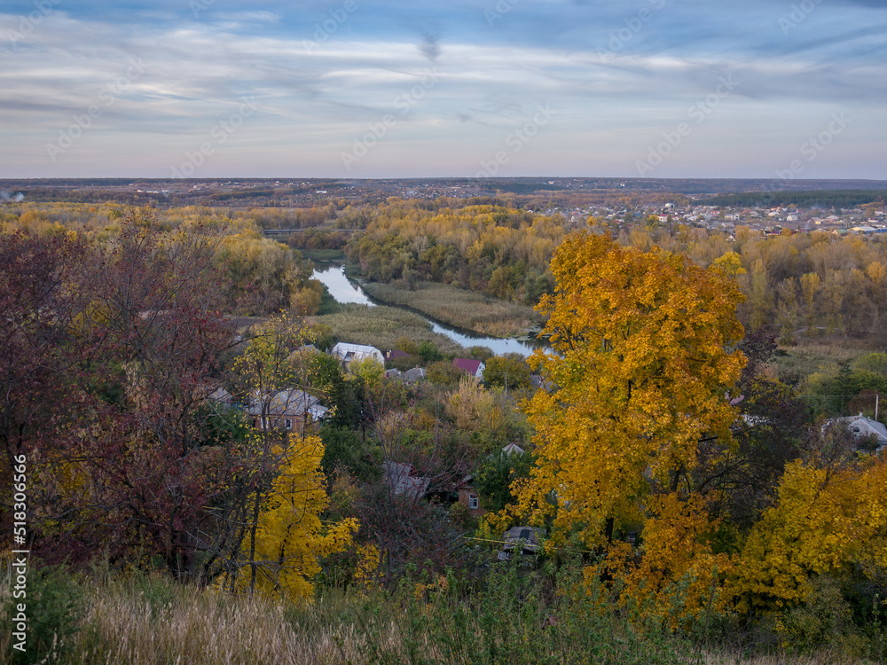 Fototapeta premium Autumn landscape with a view of the river valley, the village and the bridge. Ukraine, Chuguev