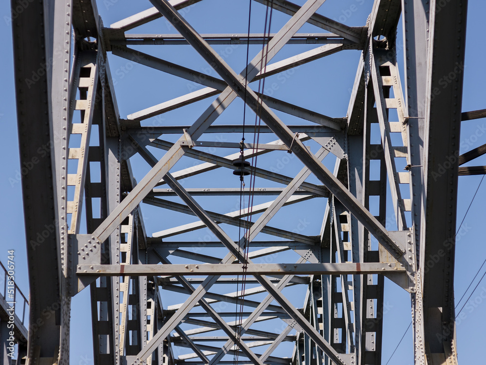 Engineering structures made of steel, part of a railway bridge, against the background of a blue sky Engineering structures made of steel, part of a railway bridge, against the background of a blue sky