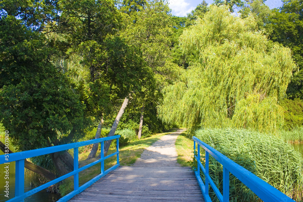 Sunny landscape with blue bridge in State Dendrological Park Trostianets in Chernigov region, Ukraine Sunny landscape with blue bridge in State Dendrological Park Trostianets in Chernigov region, Ukraine