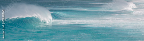 Panoramic view of waves rolling into a beach photo